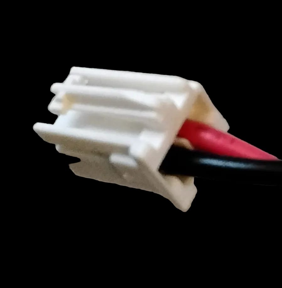 A view of the back of a white plastic wire harness connector in an aftermarket W11683242 Chrome LED Kit so that the viewer can see the red wire eters the right side of the connector when viewed with the clip side up. 
